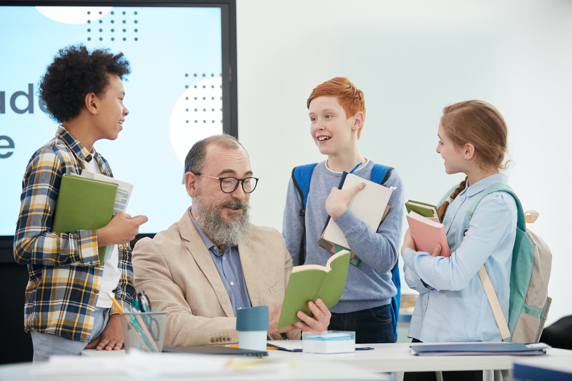 children talking to teacher in school