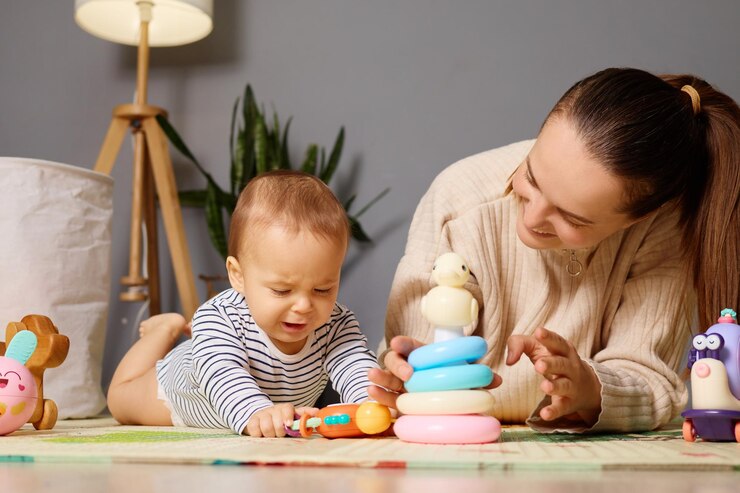 mother sits beside her baby guiding him as he plays with colorful stacking rings toys floor warm light fills cozy living room creating nurturing environment 176532 32416